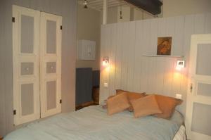 Un dormitorio con una cama con almohadas. en Le Patio en Le Puy-en-Velay