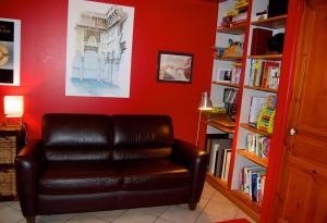 una silla de cuero en una habitación con una pared roja en Le Patio en Le Puy-en-Velay