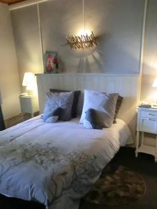 a bedroom with a large bed with white sheets and pillows at Le gîte du familistère in Guise