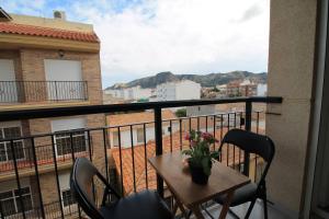 a balcony with a table with a vase of flowers on it at Piso Vacacional en Murcia in Beniaján