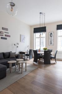 een woonkamer met een bank, stoelen en tafels bij Cozy & Bright Apartment in Antwerpen