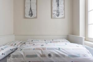 een witte slaapkamer met een bed met kussens erop bij Cozy & Bright Apartment in Antwerpen
