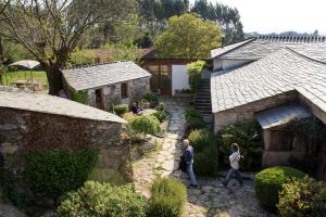 a man and woman walking through a garden in a house at Casa Roan y Casa Grande in Lodoso