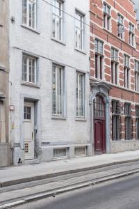 a building with a red door on a city street at Cozy & Bright Apartment in Antwerp