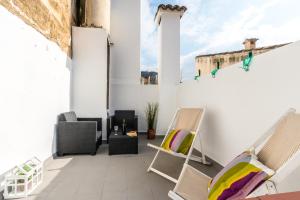 patio con sedie e tavolo su una parete bianca di Townhouse Alejandra By homevillas360 a Pollença