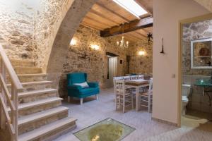 a room with a staircase and a table and chairs at Trigono Luxury House in Kissamos