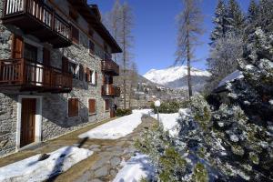a snow covered path in front of a building at Villa Sorriso in Ponte di Legno