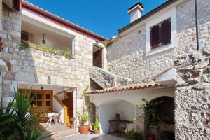 an external view of a stone house with a patio at Apartments Branko in Starigrad-Paklenica