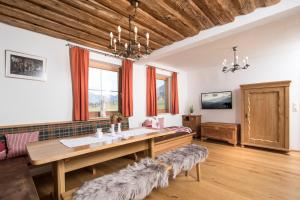 a dining room with a wooden table and some windows at Chalets Steiner in Hart im Zillertal