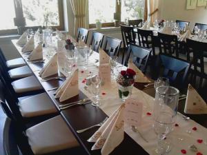 a long table with white napkins and wine glasses at Landgasthof Restaurant Laibach in Bad Berleburg