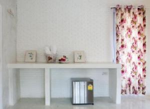 a white table with pictures on it in a room at Laemsing Whitehouse Resort in Laem Sing