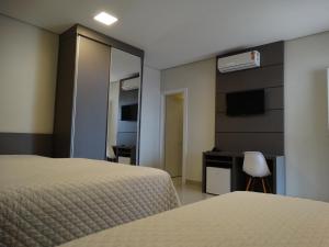 Habitación de hotel con 2 camas y espejo en Cynn Hotels, en São José dos Campos