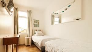a bedroom with two beds and a mirror at Logis Hôtel La Chaize in Noirmoutier-en-l'lle