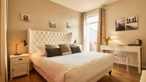a bedroom with a large white bed and a window at Logis Hôtel La Chaize in Noirmoutier-en-l'lle