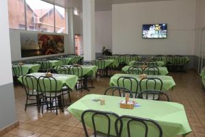 a dining room with green tables and chairs at Hotel Cariris in Pirapora