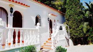 a white house with stairs and trees at Granada Apartments Familiar Deluxe in Portinatx
