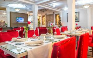 Hotel & Ryad Art Place Marrakech في مراكش: غرفة طعام مع طاولات وكراسي حمراء وشجرة عيد الميلاد