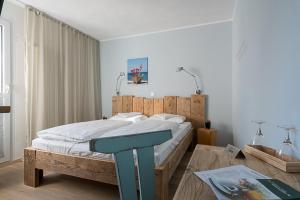 Schlafzimmer mit einem großen Bett mit einem Kopfteil aus Holz in der Unterkunft BioHotel Kassel Wilhelmshöher Tor in Kassel