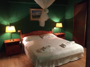 een slaapkamer met groene muren en een bed met 2 lampen bij Podere di Costabella in Conegliano