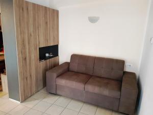 a brown couch sitting in a living room at Appartamento Buffaure in Pozza di Fassa