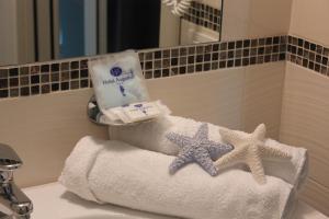 two towels and two starfish on a bathroom sink at Hotel Augustus- Davanti a noi c'è solo il mare in Misano Adriatico