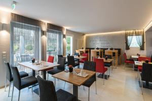 un restaurant avec des tables, des chaises et un tableau noir dans l'établissement BioHotel Kassel Wilhelmshöher Tor, à Cassel