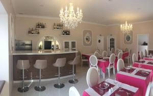 a restaurant with pink tables and chairs and a bar at The Capital Boutique B&B in Peniche