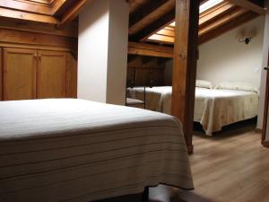 zwei Betten in einem Zimmer mit Holzdecken in der Unterkunft Viviendas Rurales Aldea de Dosamantes in Pesaguero-La Parte