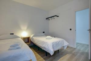 two beds in a room with white walls at Lewis&Peter Apartments Los Remedios in Ronda