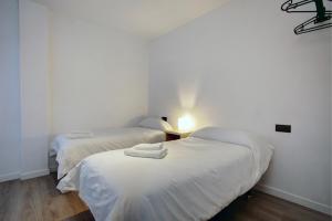 2 camas en una habitación con paredes blancas en Lewis&Peter Apartments Los Remedios, en Ronda