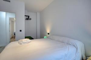 ein weißes Bett mit zwei Handtüchern darüber in der Unterkunft Lewis&Peter Apartments Los Remedios in Ronda