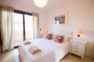 1 dormitorio con cama blanca y ventana grande en Tinajas - No Noise en Corralejo