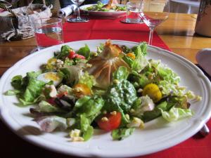 um prato branco com uma salada na mesa em Maison Iris em Villeneuve-lès-Montréal