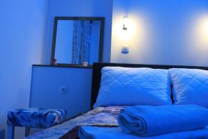 a blue bedroom with a bed and a mirror at "E&S" Apartment in Mostar