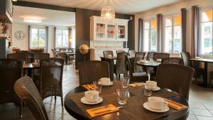 - une salle à manger avec des tables, des chaises et des fenêtres dans l'établissement La Chaize - Villa, Suites & Spa, à Noirmoutier-en-l'lle