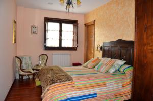 ein Schlafzimmer mit einem Bett mit einer bunten Decke in der Unterkunft Casa da Capilla in Gres