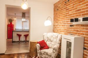 a living room with a chair and a brick wall at Apartment Cajakova in Košice