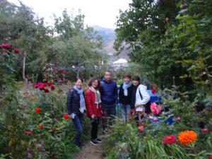 a group of people standing in a garden with flowers at Hotel MIRA in Goris