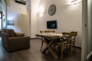 una sala da pranzo con tavolo, sedie e divano di Miklù Luxury Suite a Lecce