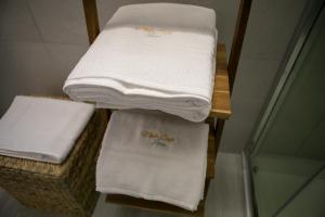 una pila di asciugamani su un ripiano in bagno di Miklù Luxury Suite a Lecce