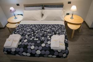 una camera da letto con un letto con due tavoli e due lampade di Miklù Luxury Suite a Lecce