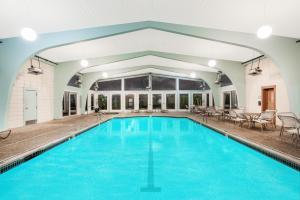 una piscina cubierta con agua azul en un edificio en Howard Johnson by Wyndham Middletown Newport Area en Middletown