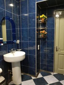 a blue tiled bathroom with a sink and a mirror at Apartment Old Tbilisi Gorgasali in Tbilisi City +58 photos