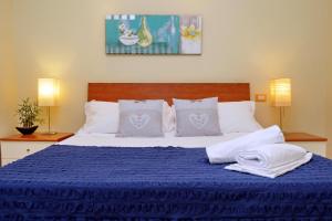 ローマにあるI Pini di Roma - Rooms & Suitesのベッドルーム1室(大型ベッド1台、青い毛布付)