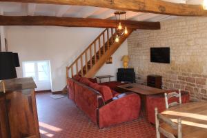 - un salon avec un canapé rouge et une table dans l'établissement La Maison du Gardien Domaine du Château des Loups, à Échiré