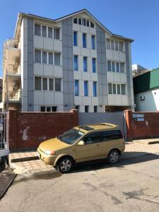 オリギンカにあるGostinitsa Morskoy Brizの建物前に停車する黄色い車