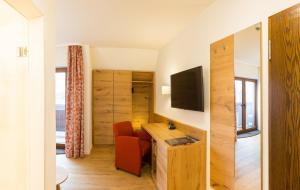 a room with a desk with a television and a chair at Hotel Fortuna in Kirchzarten