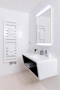 a white bathroom with a sink and a mirror at Eden Lodge Paris in Paris
