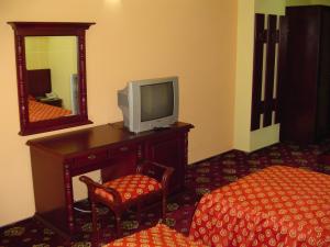 a room with a tv and a chair and a mirror at Hotel Europa in Ploieşti