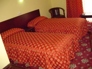 a bedroom with two beds with red comforters at Hotel Europa in Ploieşti